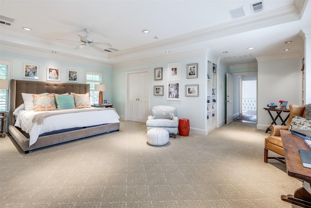 bedroom featuring a raised ceiling, crown molding, ceiling fan, and a closet