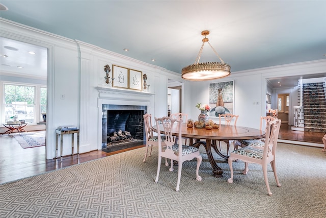 dining space with hardwood / wood-style floors and ornamental molding