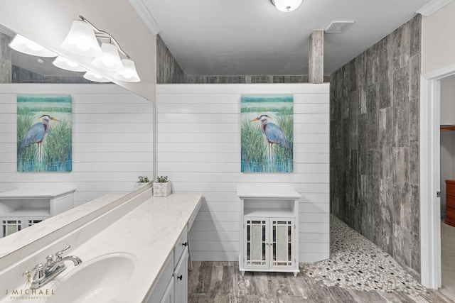 bathroom featuring vanity, wood-type flooring, ornamental molding, and walk in shower