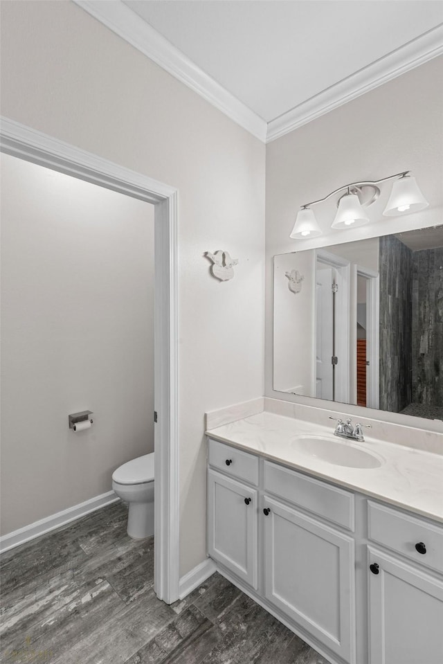 bathroom featuring ornamental molding, hardwood / wood-style floors, vanity, and toilet