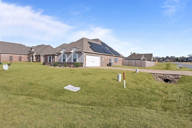 exterior space featuring a garage, a front yard, and solar panels