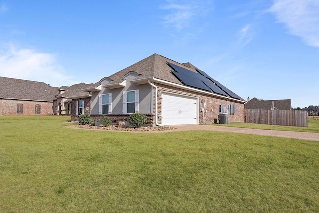 view of front facade with a garage, a front lawn, and solar panels