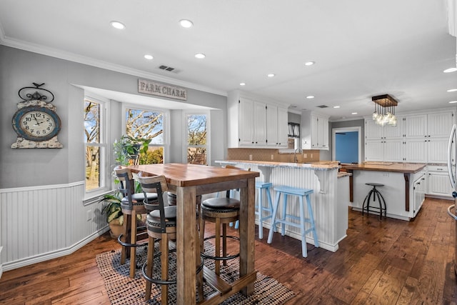 dining area with ornamental molding, dark hardwood / wood-style floors, and sink