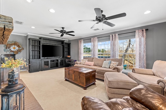 living room featuring ceiling fan, ornamental molding, and light carpet