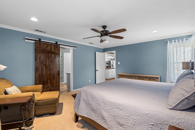 bedroom with a barn door, ceiling fan, ornamental molding, and connected bathroom