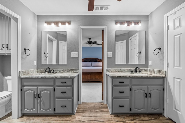 bathroom with vanity, hardwood / wood-style floors, toilet, and ceiling fan