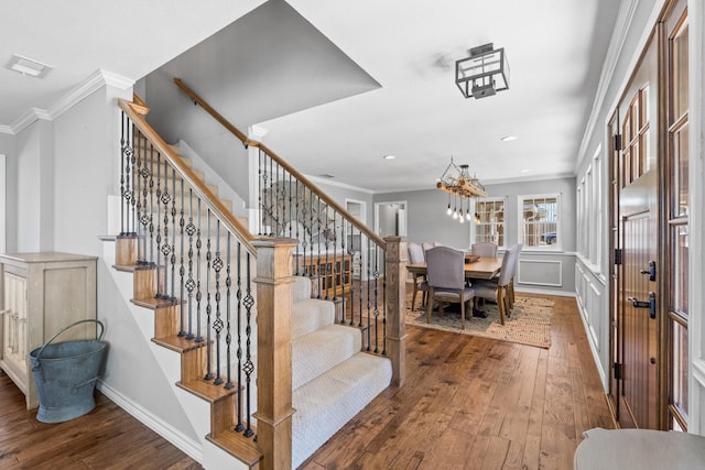 stairs featuring crown molding and wood-type flooring