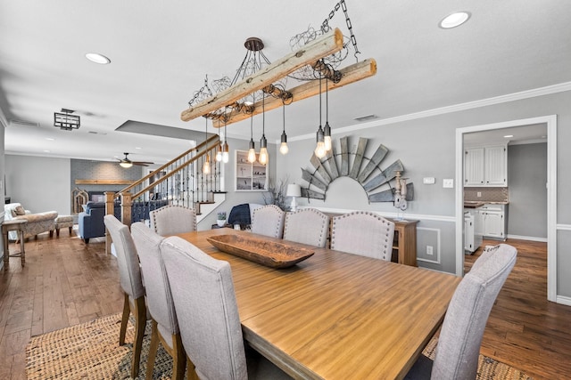 dining area featuring crown molding, dark wood-type flooring, and ceiling fan