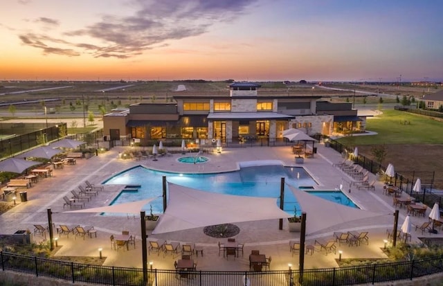 pool at dusk featuring a patio area