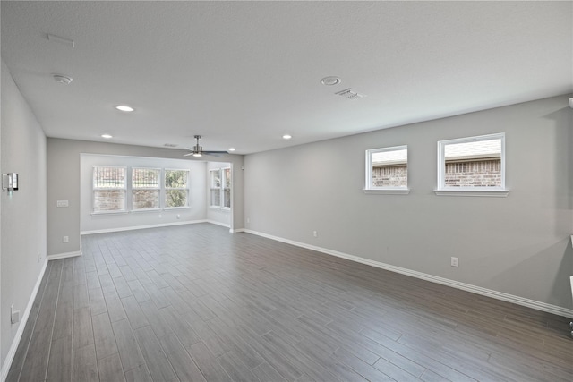 spare room with dark hardwood / wood-style floors and ceiling fan