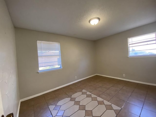 unfurnished room with tile patterned floors and a textured ceiling