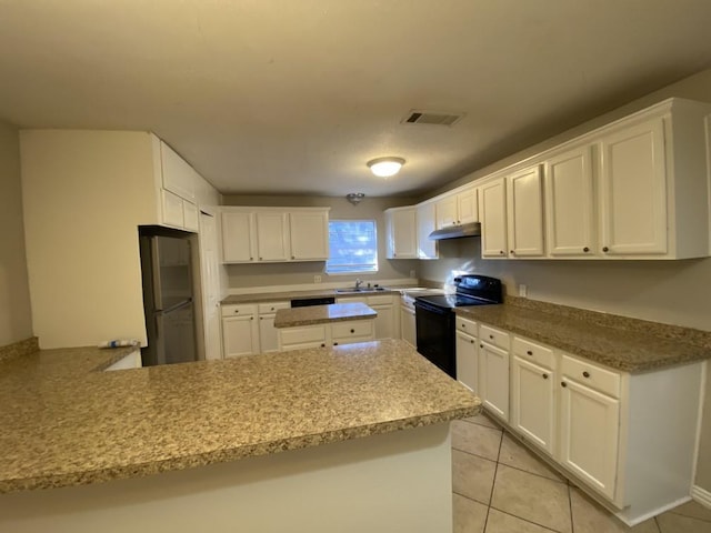 kitchen with electric range, fridge, kitchen peninsula, and white cabinets