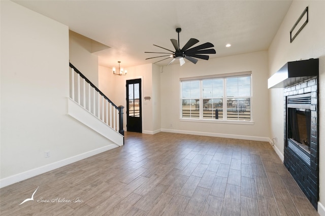 unfurnished living room featuring ceiling fan with notable chandelier