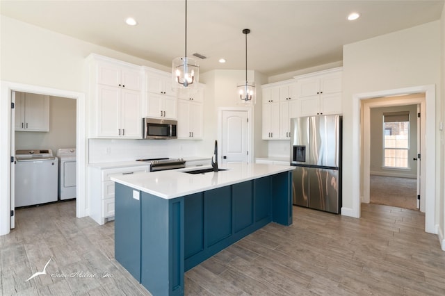 kitchen featuring white cabinetry, sink, independent washer and dryer, and appliances with stainless steel finishes