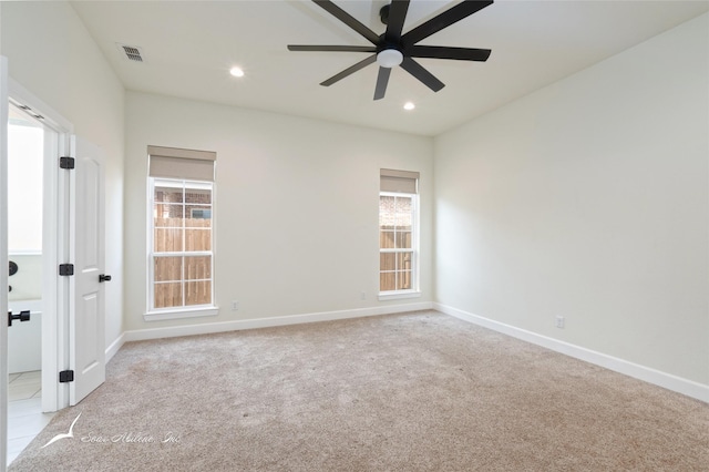 carpeted empty room featuring ceiling fan and a healthy amount of sunlight