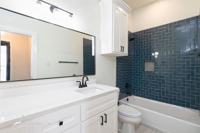 full bathroom featuring tiled shower / bath combo, vanity, and toilet