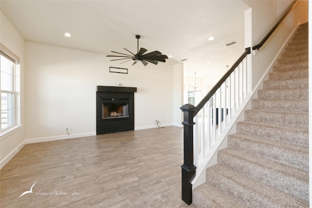 interior space with wood-type flooring and ceiling fan with notable chandelier