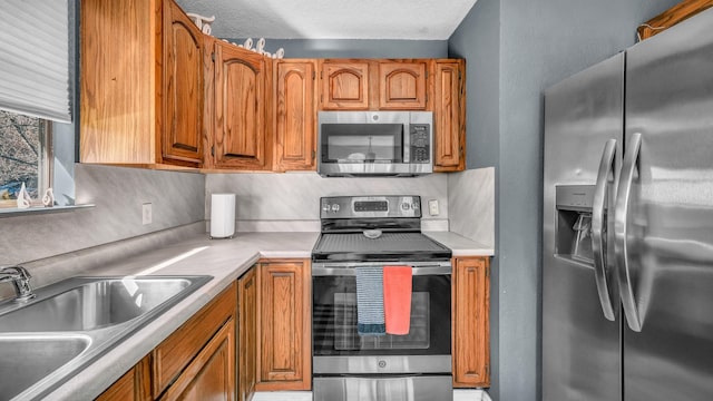 kitchen with stainless steel appliances, sink, backsplash, and a textured ceiling