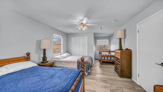 bedroom featuring light hardwood / wood-style floors, ceiling fan, and a closet