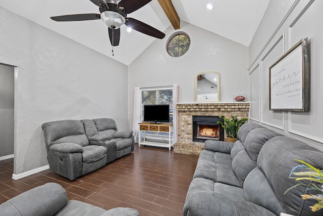 living room with ceiling fan, a fireplace, and vaulted ceiling with beams