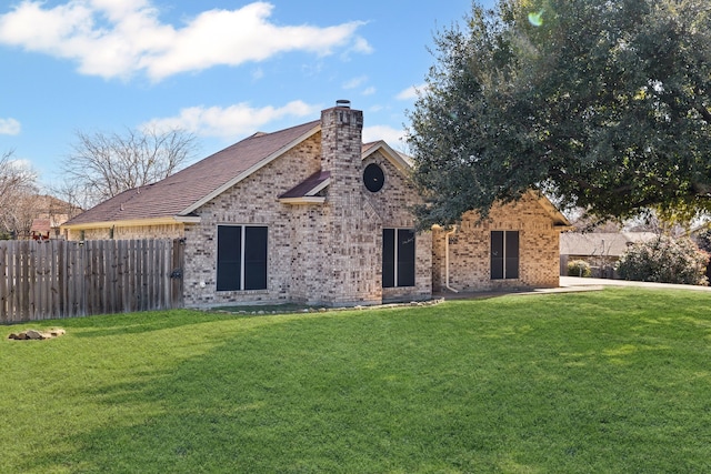 rear view of house featuring a lawn