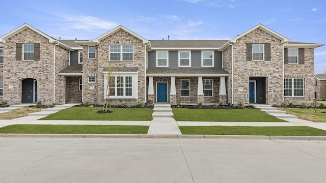 view of front of home with a shingled roof and a front lawn