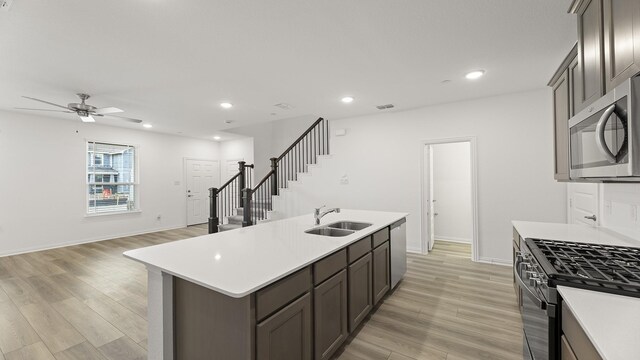 kitchen featuring light countertops, a ceiling fan, appliances with stainless steel finishes, and a sink