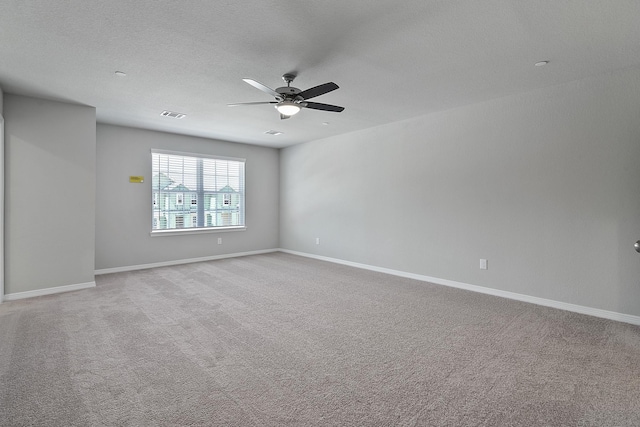 carpeted spare room featuring ceiling fan and a textured ceiling