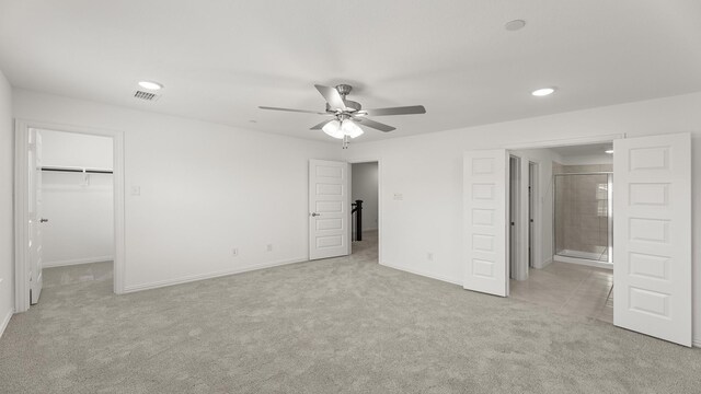 unfurnished bedroom featuring light colored carpet, recessed lighting, visible vents, and a spacious closet