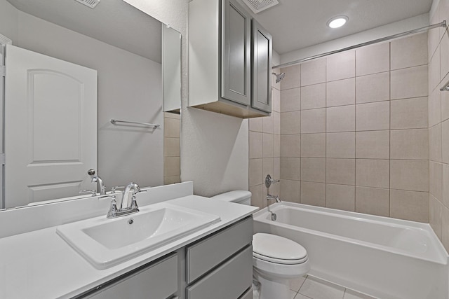 full bathroom with tiled shower / bath, tile patterned floors, toilet, and vanity