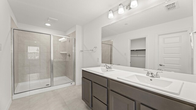 bathroom with visible vents, a sink, a stall shower, and tile patterned floors