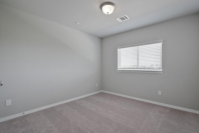 unfurnished room featuring light carpet