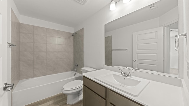 full bath with shower / bathtub combination, toilet, wood finished floors, and visible vents