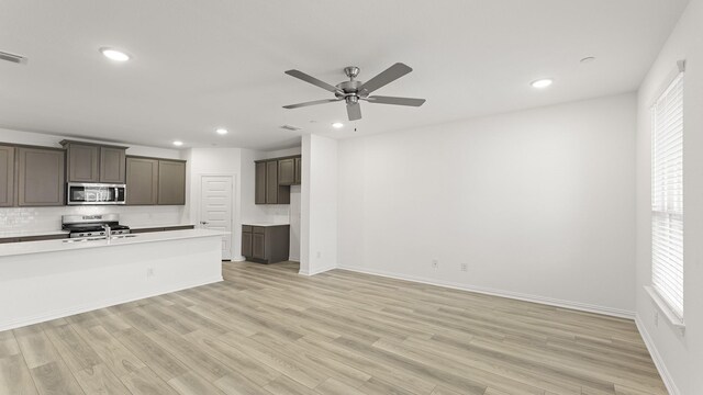 unfurnished living room featuring light wood-type flooring, a ceiling fan, plenty of natural light, and recessed lighting