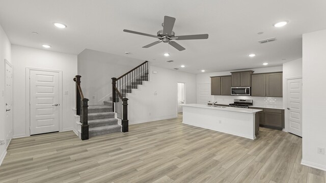kitchen featuring ceiling fan, a sink, light wood finished floors, stainless steel appliances, and visible vents
