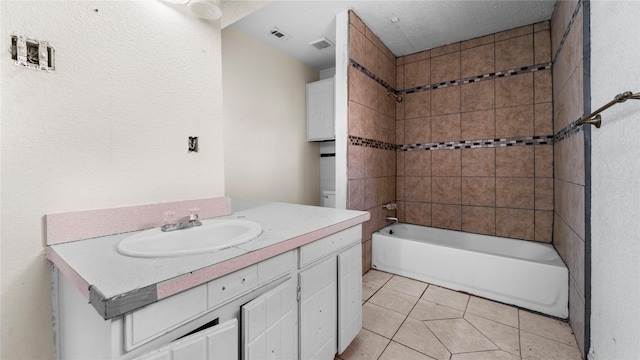 bathroom featuring tile patterned flooring, vanity, tiled shower / bath combo, and a textured ceiling