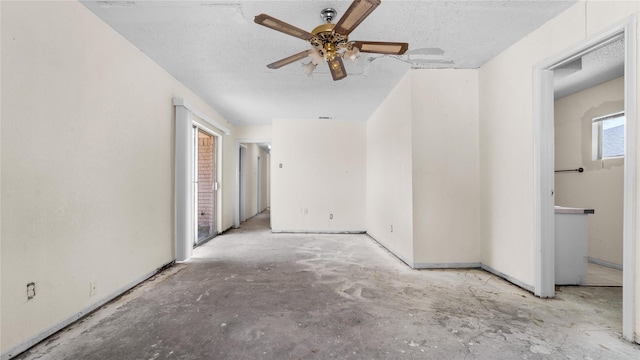 empty room with ceiling fan and a textured ceiling