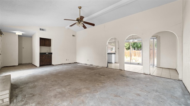 unfurnished living room featuring vaulted ceiling with beams and ceiling fan