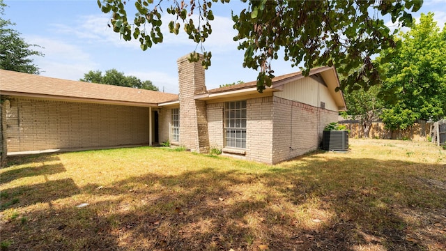 rear view of house featuring cooling unit and a yard