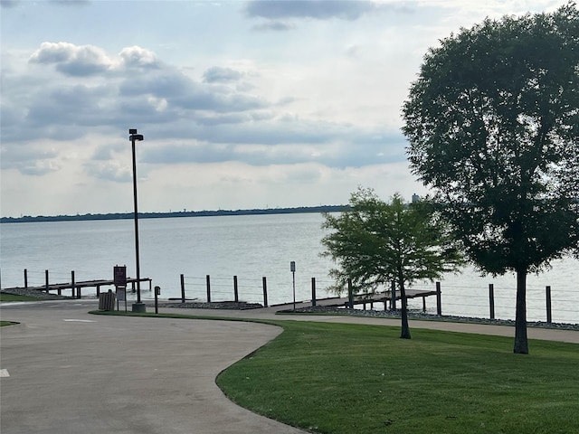 view of property's community with a yard and a water view