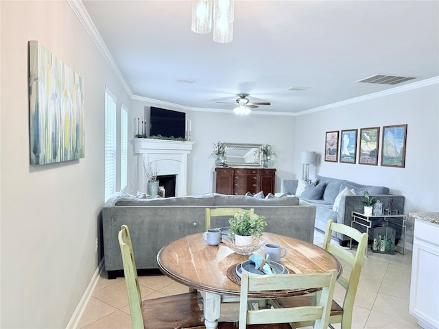 dining room with visible vents, crown molding, a fireplace, and light tile patterned floors