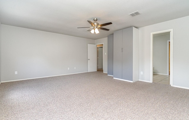 unfurnished bedroom featuring ceiling fan, connected bathroom, and light carpet