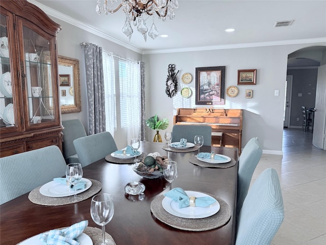 dining room featuring light tile patterned floors, visible vents, arched walkways, crown molding, and a notable chandelier