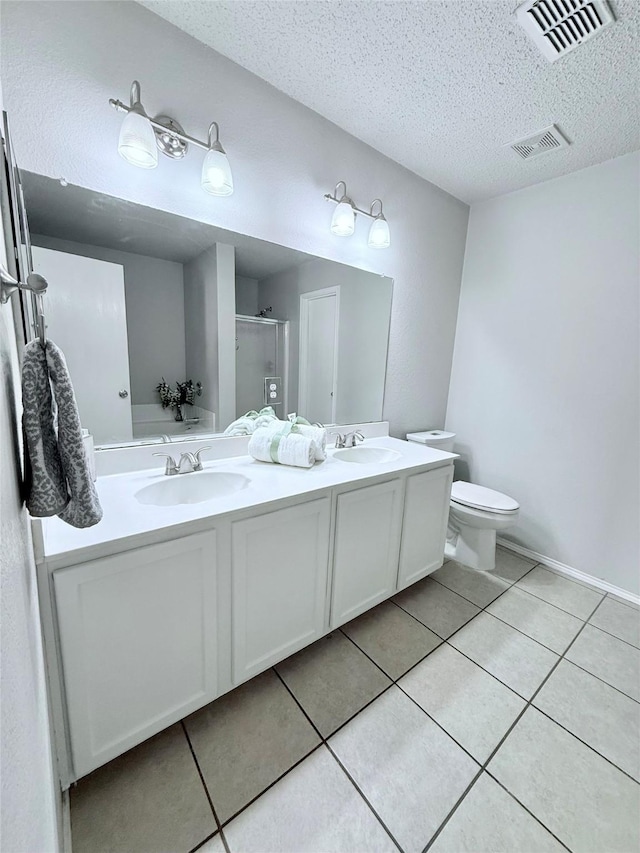 bathroom with a stall shower, visible vents, a sink, and tile patterned floors