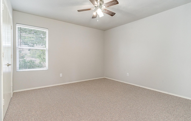 carpeted empty room featuring ceiling fan and baseboards