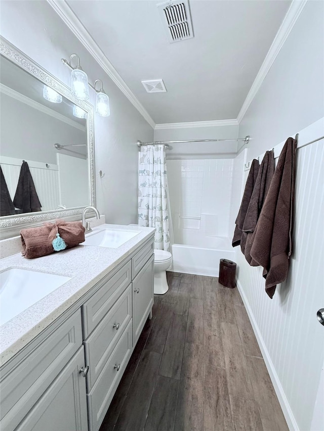 bathroom featuring a sink, toilet, wood finished floors, and visible vents