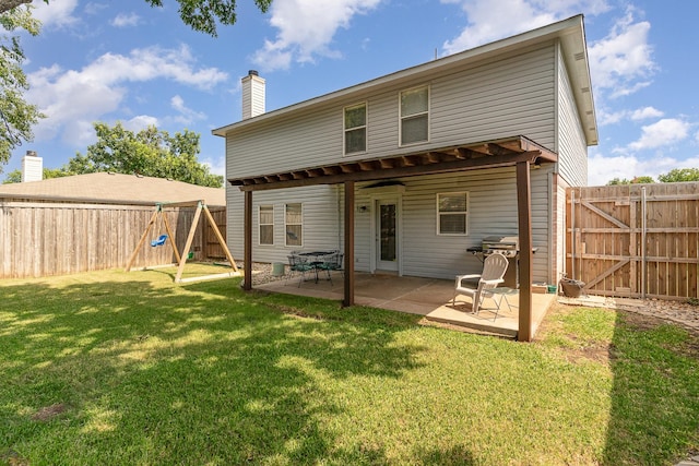 back of property with a chimney, a lawn, a gate, a patio area, and a fenced backyard