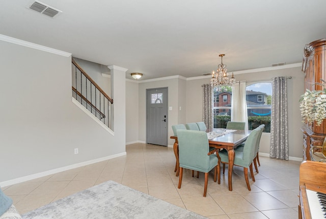 dining area with light tile patterned floors, crown molding, a chandelier, and ornate columns