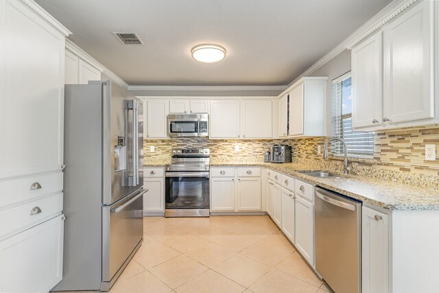 kitchen with light stone counters, decorative backsplash, and white cabinets