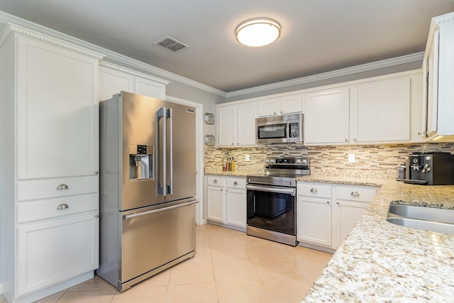 kitchen featuring visible vents, decorative backsplash, appliances with stainless steel finishes, white cabinetry, and light tile patterned flooring